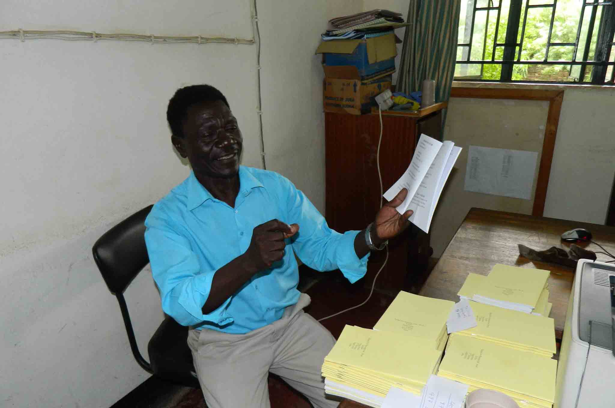 Translator and pastor Enos Dada sings from a Keliko song book.